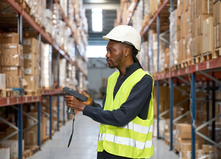 Opérateur logistique réalisant un inventaire tournant dans l'entrepôt avec un terminal WMS