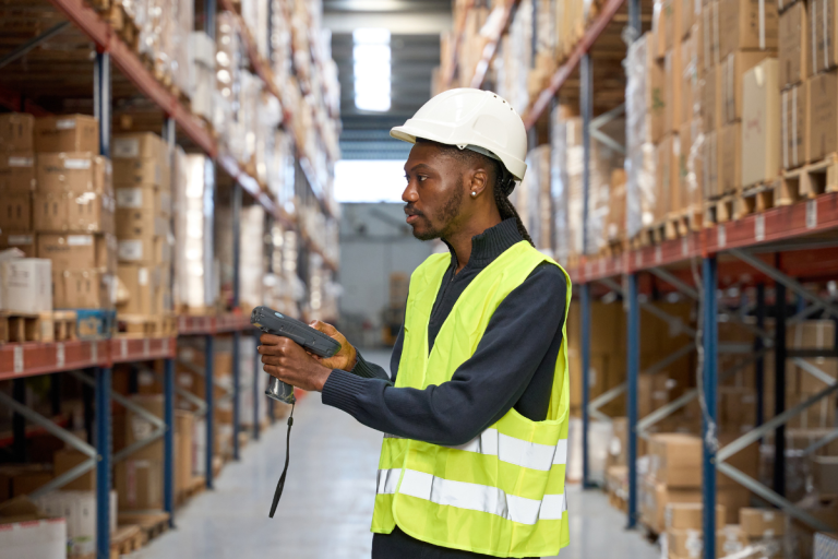 Opérateur logistique réalisant un inventaire tournant dans l'entrepôt avec un terminal WMS